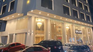A modern hotel with multiple floors, large windows, and a well-lit entrance. - SAVOYE HOTEL (Jeddah)