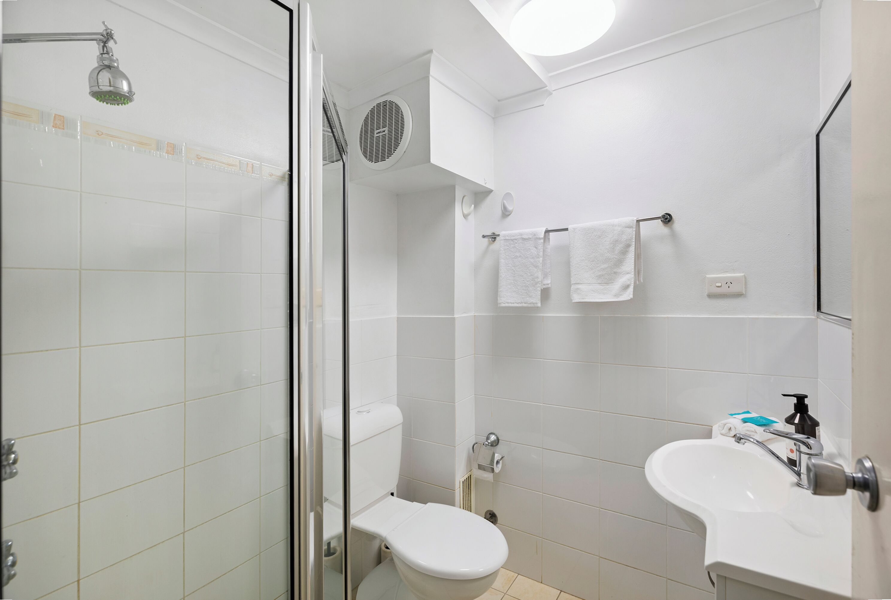 Un bagno moderno con doccia vetrata, un water e un lavandino con specchio.
