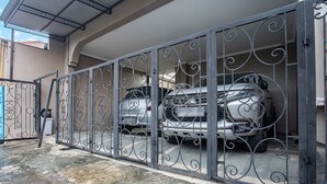 A gated parking area with a silver car parked inside. - Hotel O Almahyra Guest House Syariah (Jambi)