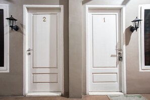 Dos puertas blancas con los números 1 y 2, cada una con una cerradura y un pomo.
