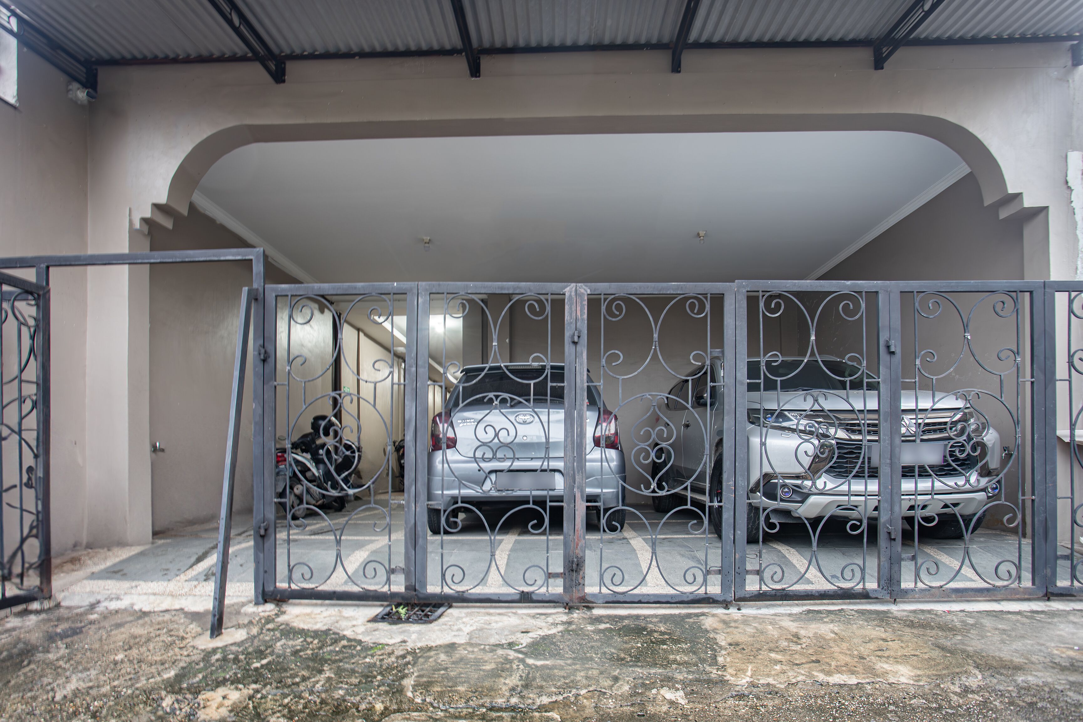 A gated parking area with two cars parked inside.
