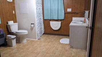 Un baño con inodoro, lavabo y perchero para toallas.