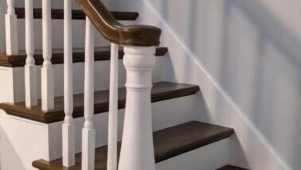 A staircase with white balusters and dark wooden steps.