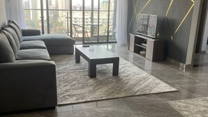 Una sala de estar moderna con un sofá modular, una mesa de centro y un mueble para televisión.