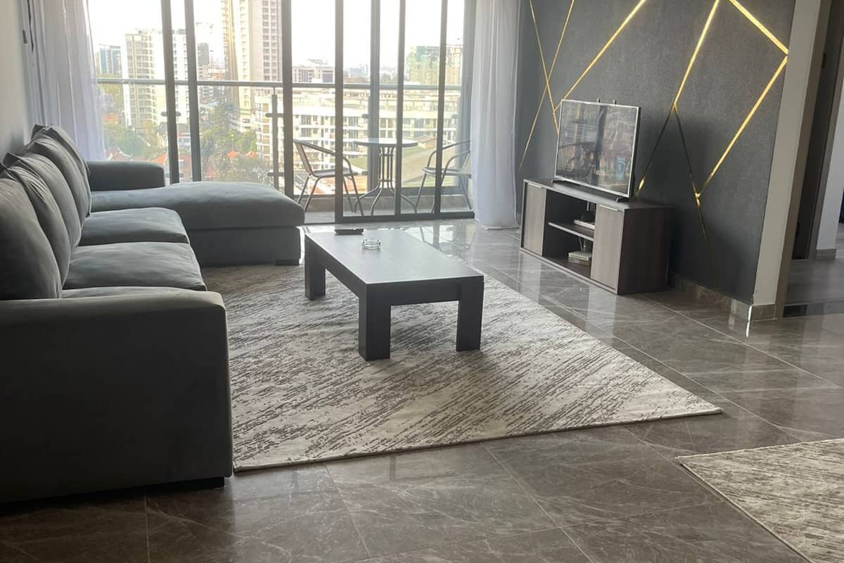 A modern living room with a sectional sofa, a coffee table, and a TV stand.