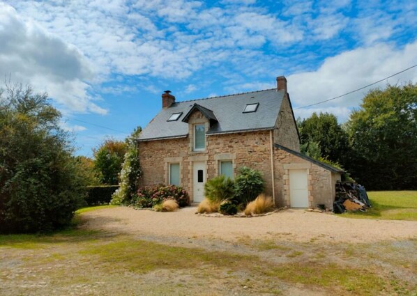 Stunning two-story house with a pitched roof and attached garage, featuring a front entrance and chimney.