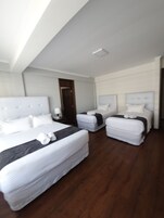 Habitación cuádruple | Ropa de cama de alta calidad y edredones de plumas