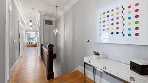 Un couloir doté d’un plancher en bois, de murs blancs et d’un plafond équipé d’un système d’éclairage encastré.