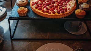 Un buffet proposant une variété de desserts, notamment des tartes, des pâtisseries et des viennoiseries.