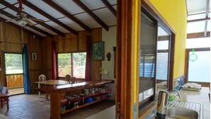 Een ruime keuken met een groot eiland, houten kasten en uitzicht op de omgeving.
