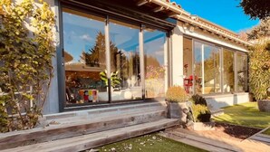 A modern house with large glass windows, a wooden deck, and a well-maintained garden. - Charmante Maison, Piscine, Spacieuse, 5 mn Aix (Aix-en-Provence)