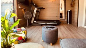 A compact room with a wooden floor, a treadmill, a fan, a mirror, and a potted plant. - Charmante Maison, Piscine, Spacieuse, 5 mn Aix (Aix-en-Provence)