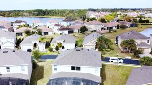 Zona residencial con casas, una piscina y un lago al fondo.