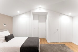 A bedroom with a bed, a door, and a light fixture. - Casa D. Adelaide T3 (Azurara)