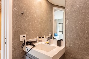 Deluxe appartement | Badkamer | Een douche, een haardroger, zeep, shampoo