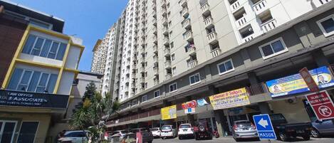 A multi-story building with commercial establishments on the ground floor, including a law office and a market.
