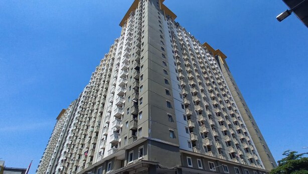 A high-rise residential building with multiple balconies and a clear sky. - OYO 93480 Apartement Gateway Cicadas By Kelola Room (Bandung)