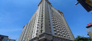 Un immeuble résidentiel de grande hauteur, doté de nombreux balcons, avec un ciel dégagé.