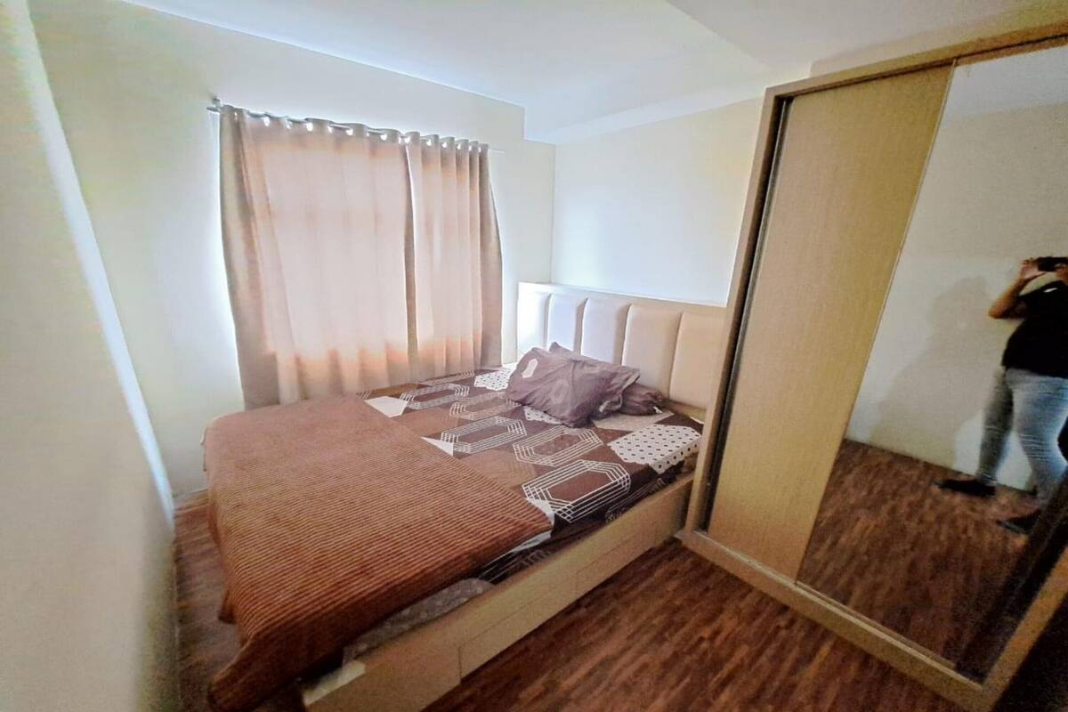Ein Schlafzimmer mit einem Bett, einem Spiegel und einem Kleiderschrank.
