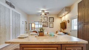 A kitchen with a marble countertop, wooden cabinets, a ceiling fan, and wall-mounted artwork. - Peaceful Ellsworth Vacation Rental w/ Grill (Ellsworth)
