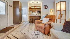 A spacious living room with a leather sofa, a coffee table, and a rug. - Peaceful Ellsworth Vacation Rental w/ Grill (Ellsworth)