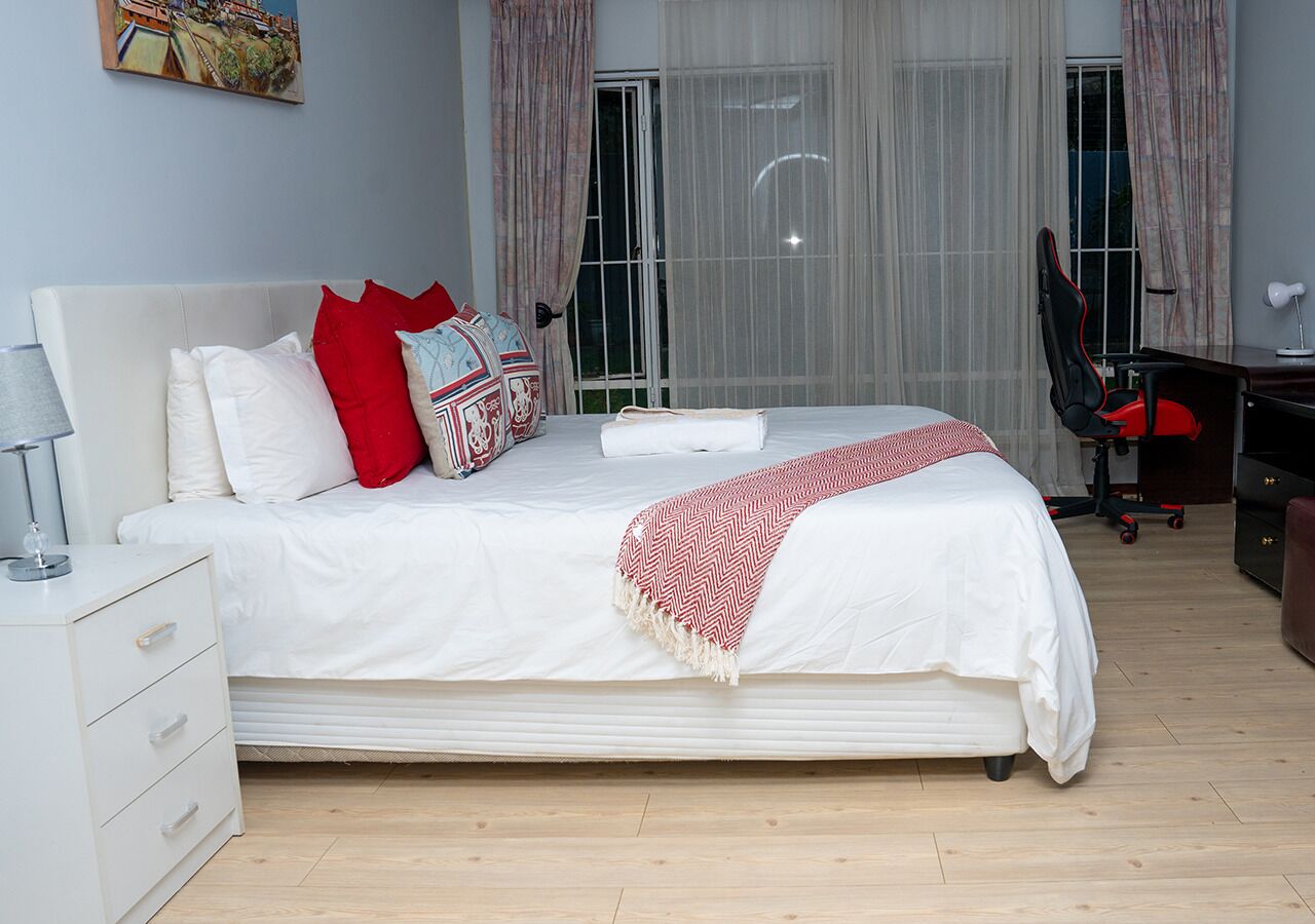 Une chambre bien rangée, avec un lit, un bureau et une chaise.