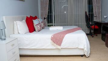 Une chambre bien rangée, avec un lit, un bureau et une chaise.