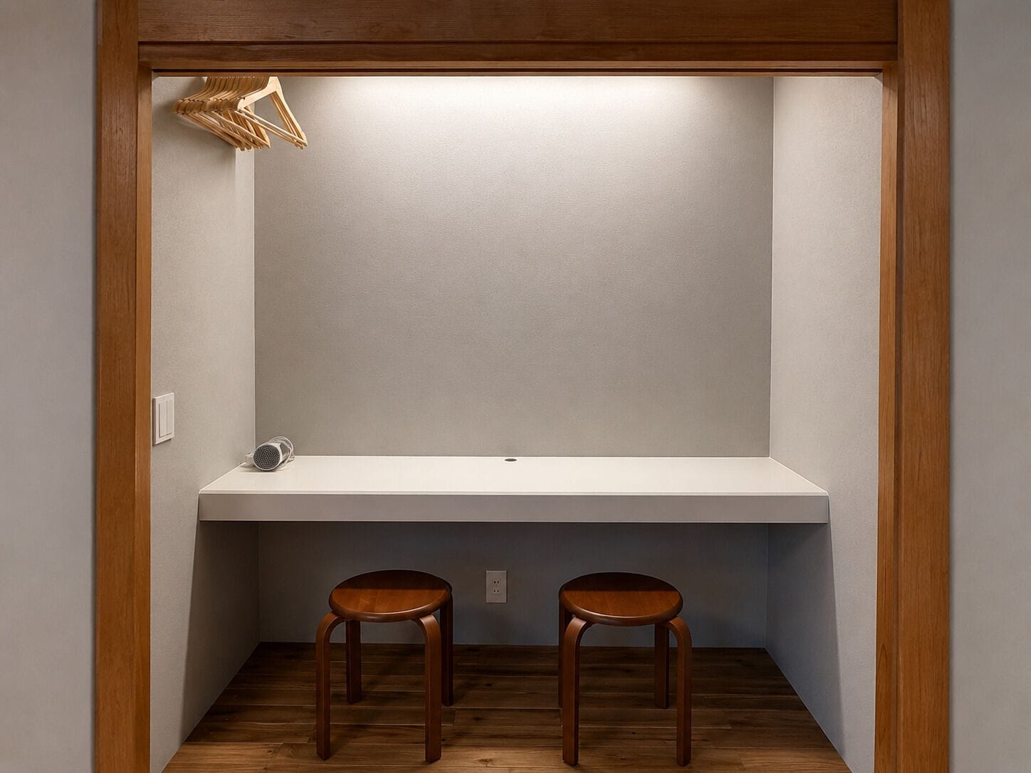 A small, enclosed room with a wooden floor, a white bench, and two wooden stools.