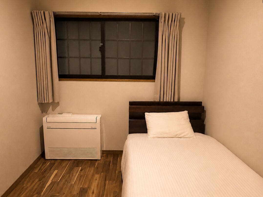 Una camera da letto con un letto, un termosifone e una finestra con tende.