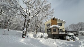 A two-story building with a snow-covered roof and a balcony. - Daiju Myoko (Myoko)