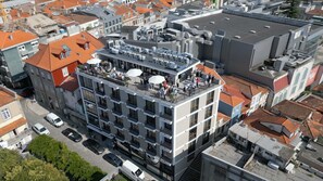 En byggnad med flera våningar, en takterrass, balkonger och en parkeringsplats.