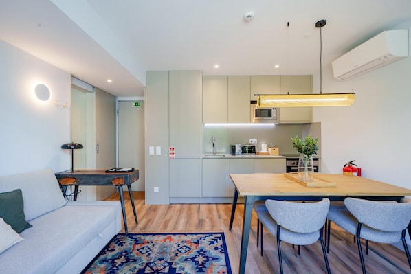 Une cuisine moderne équipée d’un four à micro-ondes, d’une cuisinière et d’un coin repas avec des chaises et une table.