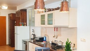 Une cuisine moderne avec des meubles blancs, un îlot central et des luminaires suspendus.