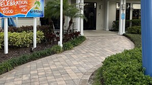 Restaurante chamado 'Breezes' com uma placa anunciando 'Sunset Celebration' e entrada acessível para cadeiras de rodas.