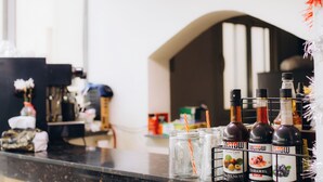 A bar area with bottles of GOSTOW hazelnuts, caramel, and plum syrups, and mason jars with straws. - Regent Pyramids View (Giza)