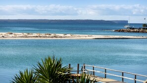 A coastal view with a clear sky, calm sea, and a sandy beach.