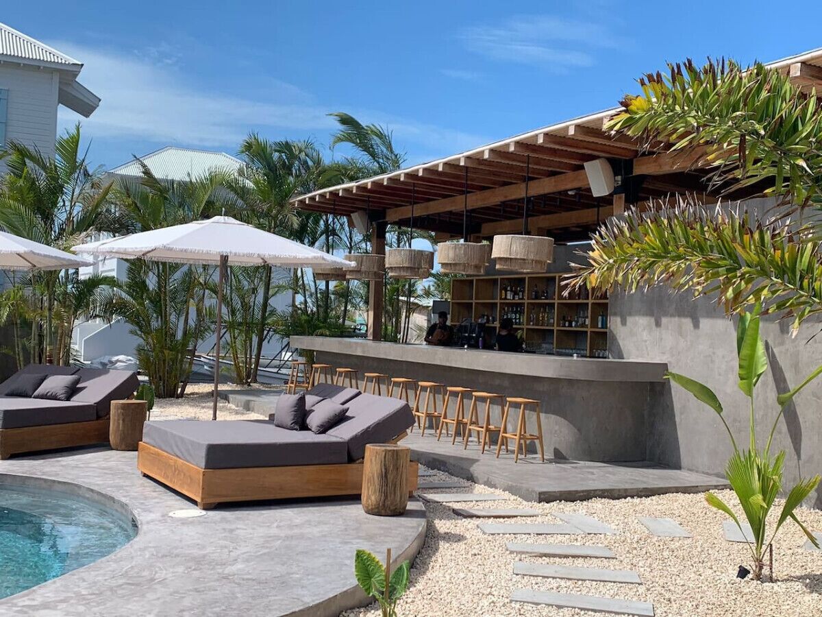 A poolside area with lounge chairs, a bar, and a covered seating area.