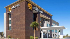 A La Quinta hotel with a modern design, featuring a prominent sun logo, a covered entrance, and a well-maintained exterior. - La Quinta Inn & Suites By Wyndham Yuma (Yuma)