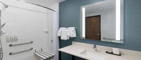 Un baño moderno con bañera, lavamanos, espejo y ducha.