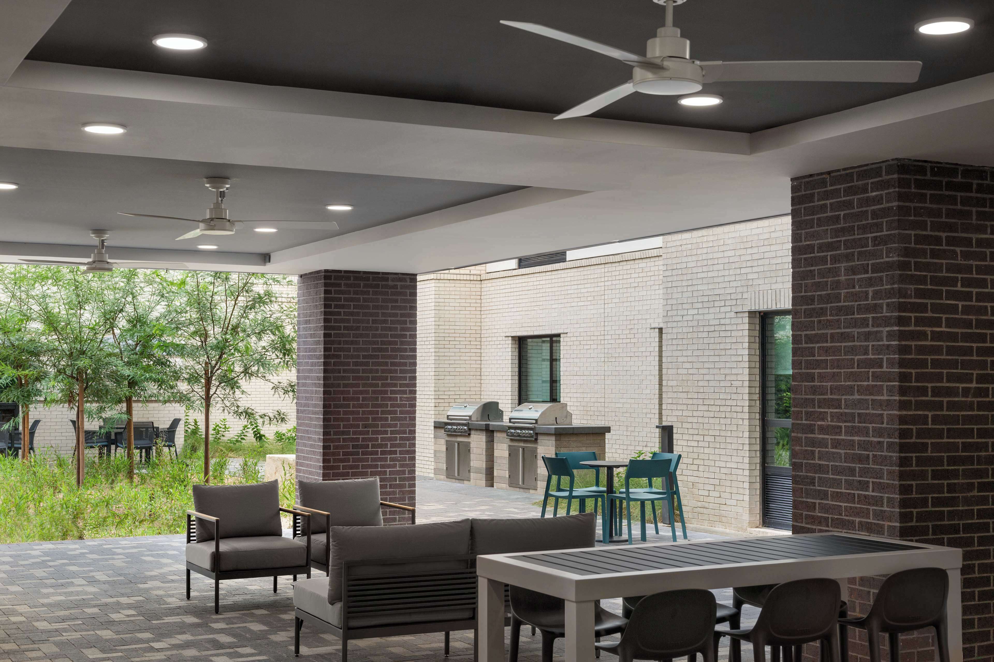 An outdoor patio with seating, a grill, and a view of the surrounding area.