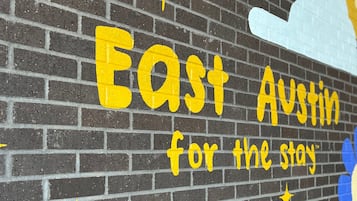 Un mur de briques sur lequel est peint en jaune le texte suivant : « East Austin, l’endroit idéal pour votre séjour ».