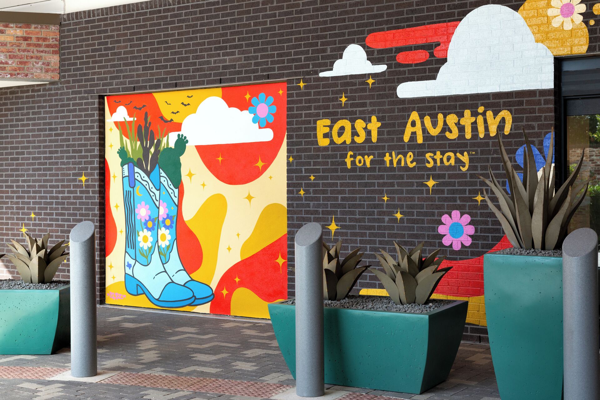 A colorful mural with the text "East Austin for the stay" on a brick wall.