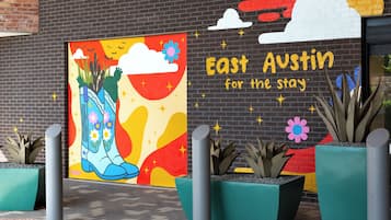 A colorful mural with the text "East Austin for the stay" on a brick wall.