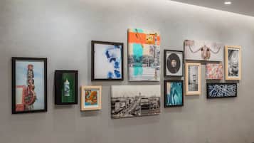 Una galería de cuadros con diversas obras de arte enmarcadas, incluyendo pinturas y fotografías.