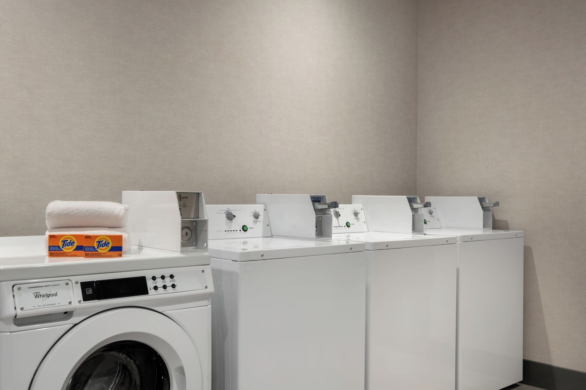 A commercial duty washer with Tide detergent and a Whirlpool brand dryer.