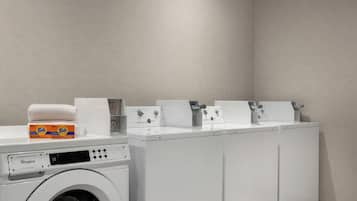 A commercial duty washer with Tide detergent and a Whirlpool brand dryer.