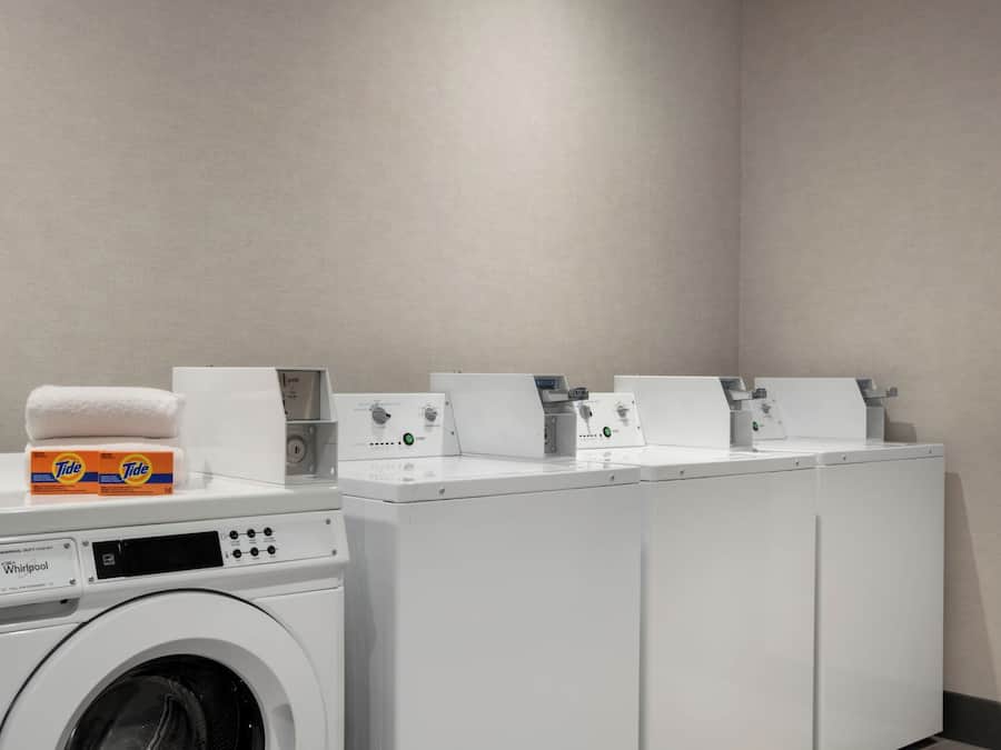 A commercial duty washer with Tide detergent and a Whirlpool brand dryer.