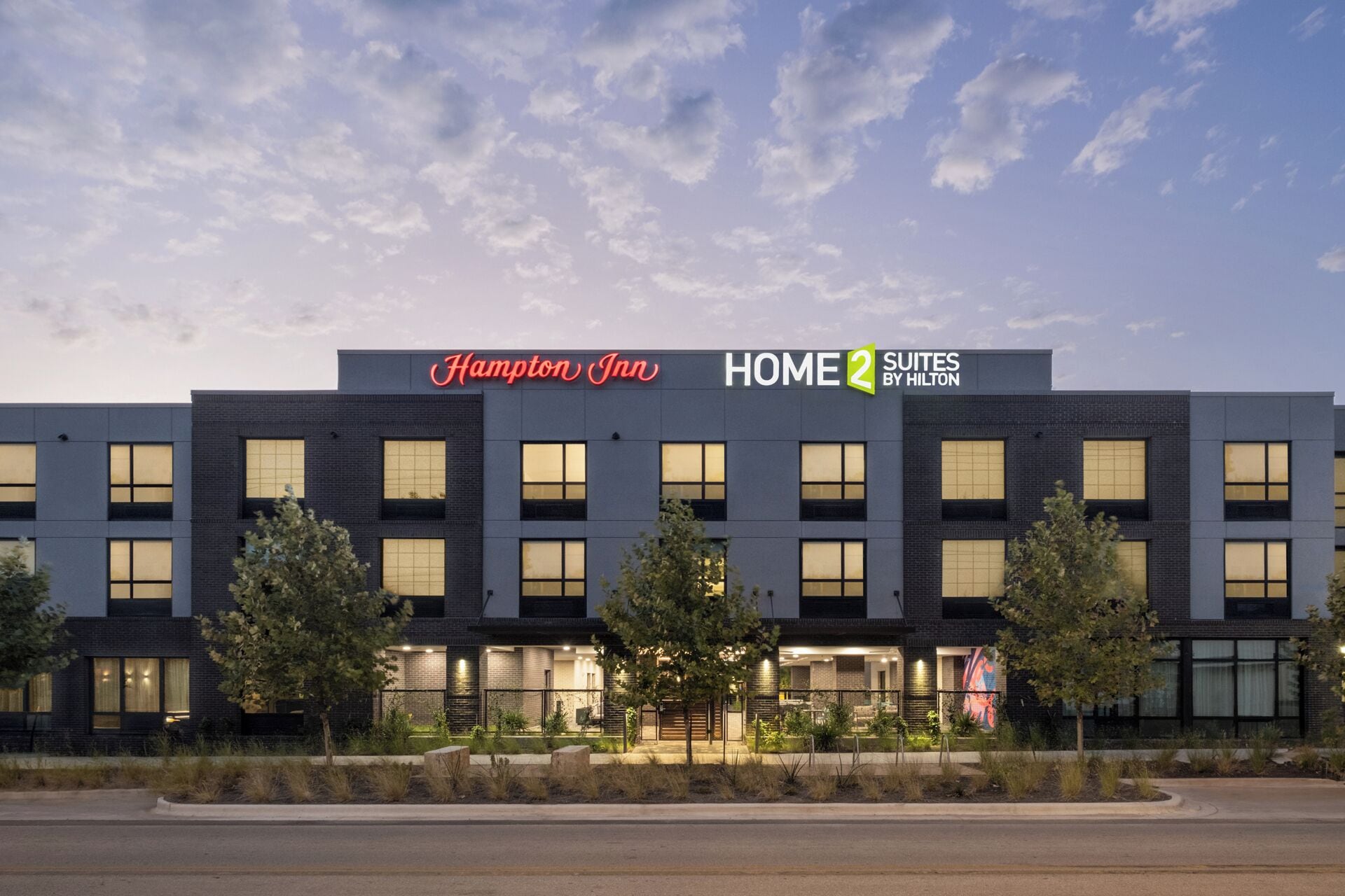 Un hôtel Hampton Inn au design moderne, doté d’une enseigne bien visible et d’une façade bien éclairée.