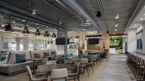 Un interior moderno con una amplia zona de comedor, diferentes disposiciones de asientos y un bar.
