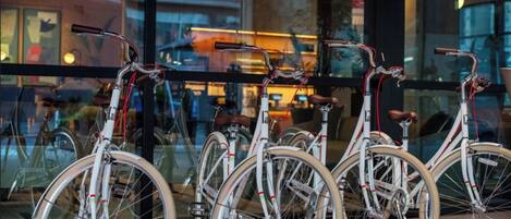 A row of bicycles parked outside a building with large windows.